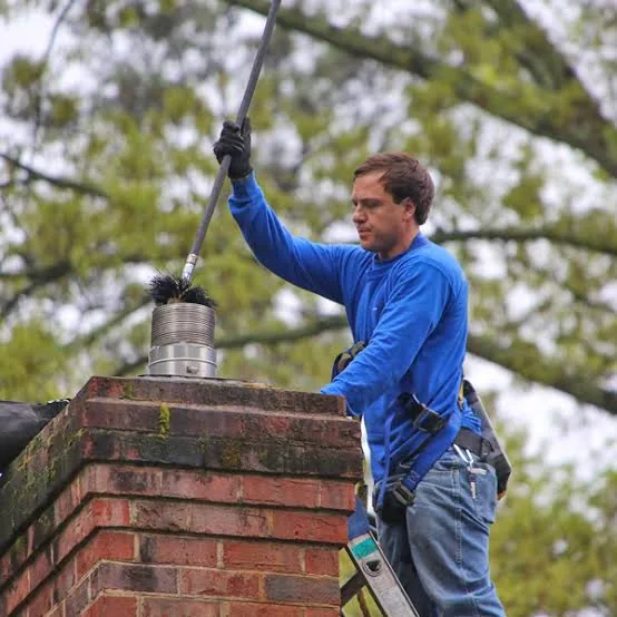 Flexible cleaning rod being lowered into a metal-lined chimney flue