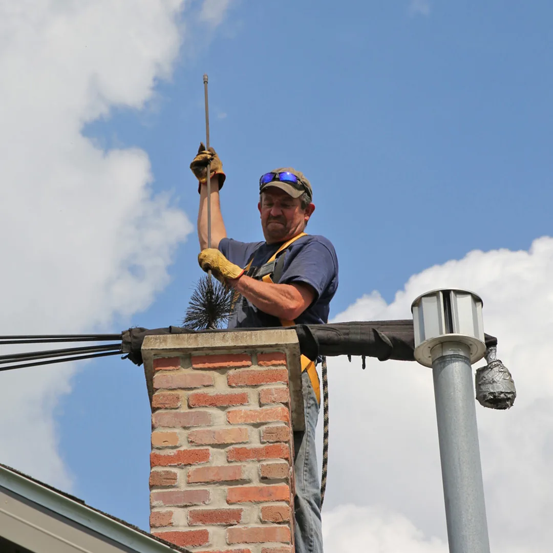 Chimney cleaning rod positioned above a residential brick flue